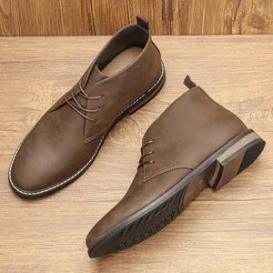 Detailopname van bruine retro heren desert boots met leertextuur en witte stiksels