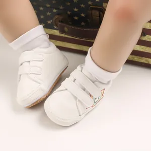 Gros plan de chaussures de marche blanches pour bébé avec double bride à scratch