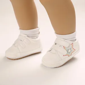 Chaussures blanches pour bébé avec broderie d'étoiles colorées et doubles scratchs.