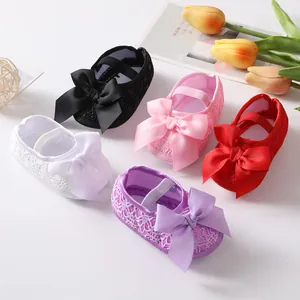 Detailansicht von Spitzen-Babyschuhen mit weicher Sohle und eleganten Bandschleifen