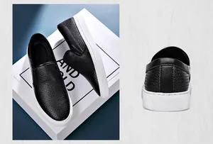 Dettaglio di scarpe slip-on in pelle nera con trama a grana e suola bianca