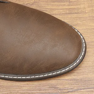 Detailopname van de neus en witte stiksels van vintage bruine lederen desert boots voor heren