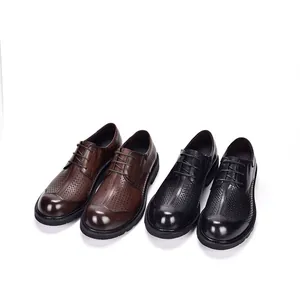 Detailopname van zwarte en bruine geperforeerde leren herenschoenen met dikke zolen
