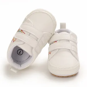 Détail de chaussures de marche blanches pour bébé avec broderie étoile et scratchs