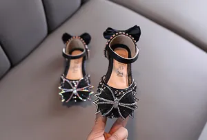 Détail de chaussures de princesse noires pour filles avec nœuds en strass et semelles souples