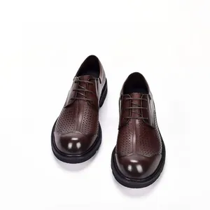 Detailweergave van stijlvolle bruine herenschoenen van geperforeerd leer met dikke zolen