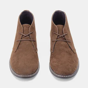 Gedetailleerd vooraanzicht van bruine suède desert boots voor heren met vetersluiting