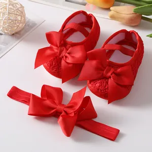 Detailed macro view of red lace baby princess shoes and matching bow headband set for infants