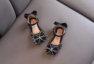 Vue détaillée des sandales de princesse noires pour filles avec nœuds en strass brillants.