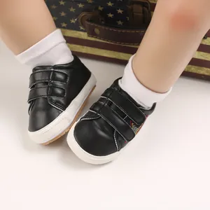 Gros plan de chaussures de marche pour bébé en similicuir noir avec bandes velcro sur modèle