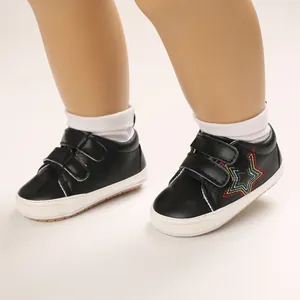 Gros plan sur des chaussures de marche pour bébé noires avec broderie étoile colorée