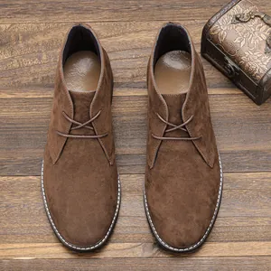 Bovenaanzicht van retro bruine suède heren desert boots op een houten ondergrond