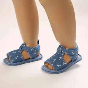 Gros plan de sandales pour bébé en denim bleu avec motif ancre pour 0-1 an.