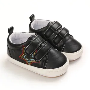 Détail de chaussures de marche pour bébé noires avec broderie d'étoile et velcro