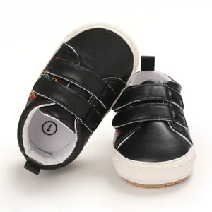 Détail de chaussures de marche noires pour bébés avec attaches velcro pour 0-1 an.