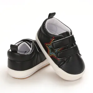 Détail de chaussures de marche pour bébé noires avec broderie étoile et brides velcro