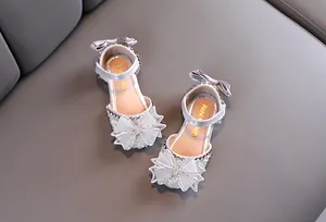 Vue détaillée de sandales de princesse argentées pour filles avec strass et nœuds brillants.