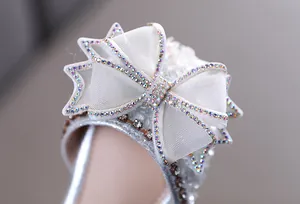 Gros plan détaillé d'un nœud en strass étincelant sur d'élégantes chaussures de princesse