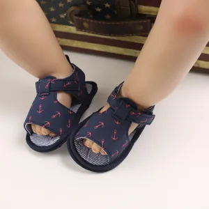 Détail de sandales bébé bleues avec motif ancre rouge et semelle rayée