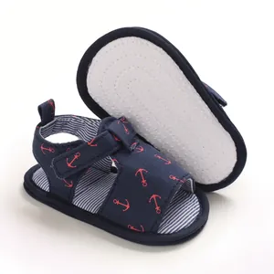 Détail de sandales bébé bleu marine avec ancres et semelle souple antidérapante.