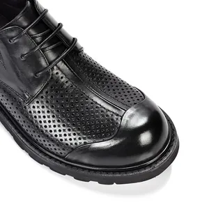 Gedetailleerde macro-weergave van zwarte geperforeerde leren herenschoenen met dikke zool