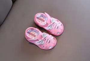 Detailansicht rosa Kleinkind-Sandalen mit silberner Glitzerschleife und Blumenmuster