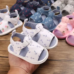 Gros plan de sandales blanches pour bébé avec motifs d'ancre et semelles souples