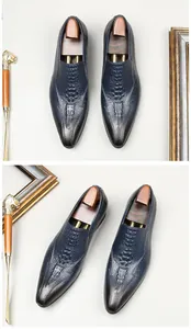 Detailed view of men's navy blue loafers with crocodile pattern and pointed toe design
