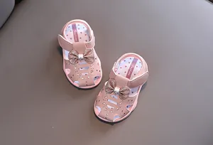 Detailansicht der rosa Babysandalen mit glitzernder Schleife und Strassakzenten.