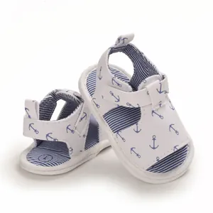 Détail de sandales d'été pour bébé en tissu blanc avec motifs d'ancres bleues et semelles souples