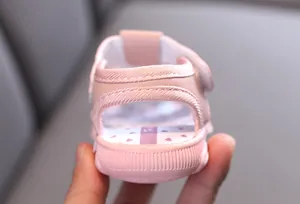 Detail von rosa Lauflern-Sandalen für Babys mit weicher Ferse und Herzmuster