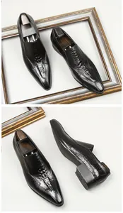 Detail view of men's crocodile embossed black leather loafers with a pointed toe design