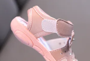 Detailansicht der Fersenriemen und Klettverschluss einer rosa Kleinkindsandale