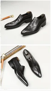 Detail of black men's pointed toe loafers with crocodile embossed leather texture.