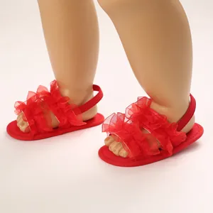 Primer plano detallado de sandalias rojas con volantes y suela blanda para bebés en verano
