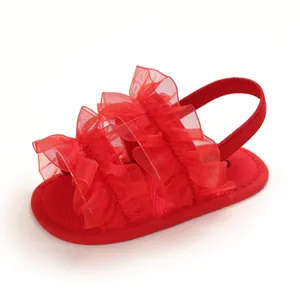Detalle de sandalias rojas para bebé con volantes y correa elástica para lactantes