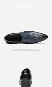 High-quality detail view of men's pointed loafers with embossed crocodile texture in navy blue