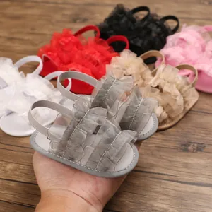 Primer plano de sandalias de suela blanda para bebé niña con volantes de malla
