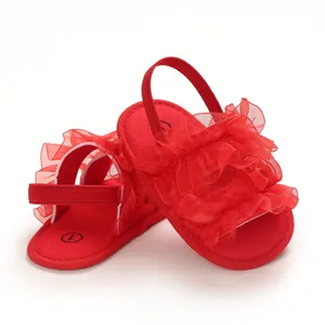 Macro view of red baby sandals with ruffled mesh detail and soft elastic back strap.