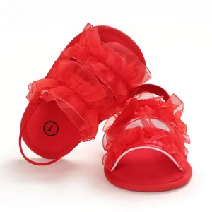 Red baby soft sole sandals with tulle ruffles and elastic heel strap for infants.