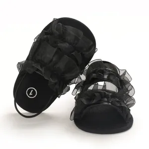 Detailed macro view of black ruffled tulle baby sandals featuring soft flexible soles