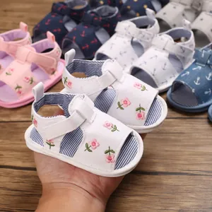 Gros plan de sandales blanches pour bébé avec broderie florale et semelle souple