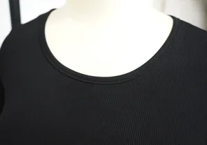 Close-up of black ribbed high-stretch fabric and round neckline of a women's sports set.