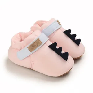 Vue détaillée de chaussures bébé en coton rose avec queue de dinosaure et bride 'Baby'