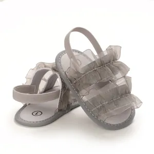 Detailed view of grey baby sandals with elegant mesh ruffle layers and soft sole.