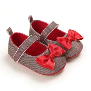 Detaillierte Ansicht von Baby-Lauflernschuhen mit großer roter Satinschleife für Mädchen