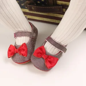 Detailansicht funkelnder Baby-Prinzessin-Schuhe mit roten Schleifen und weichen Sohlen.