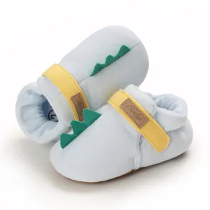 Chaussures souples pour bébé avec queue de dinosaure verte et bride jaune détail