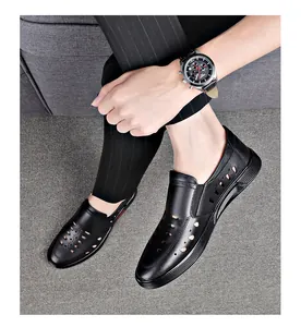 Close-up of men's black leather hollow-out sandals worn with business casual attire.