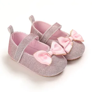 Detailansicht von rosa glitzernden Baby-Prinzessin-Schuhen mit Satinschleife und weicher Sohle.
